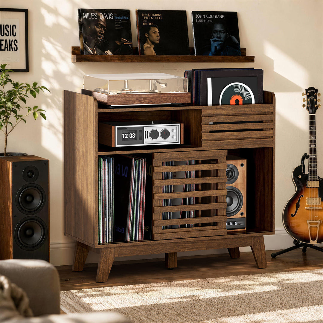 Wooden record player console with vinyl records and speakers in a room setting.