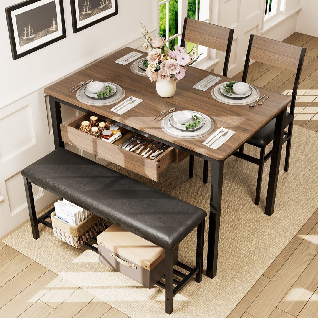 Dining table set with chairs, bench, and decor in a room with large windows.