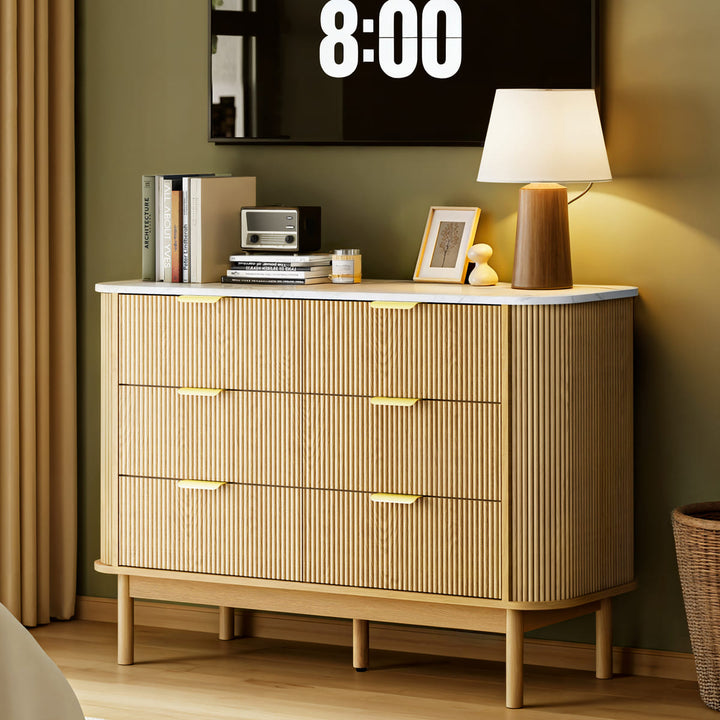 Wooden dresser with decorative items against a green wall