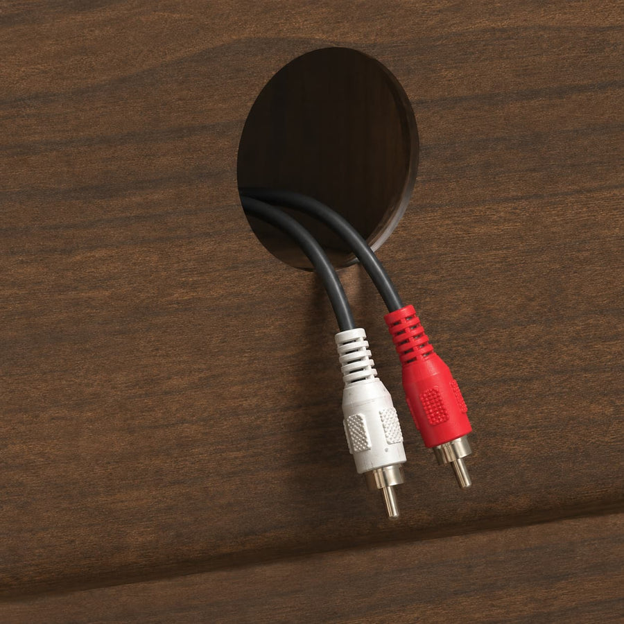 A close-up of two audio/video cables exiting a round hole in a dark brown wood panel. One cable has a white RCA connector and the other has a red RCA connector, both with gold-plated pins.