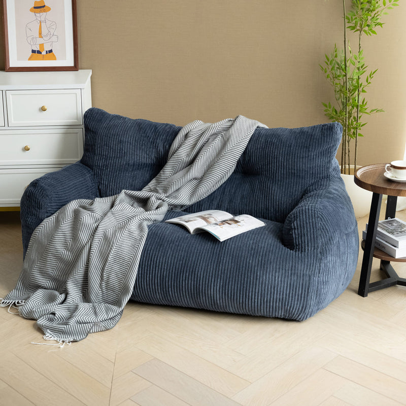 Blue bean bag chair with a blanket and book in a living room setting