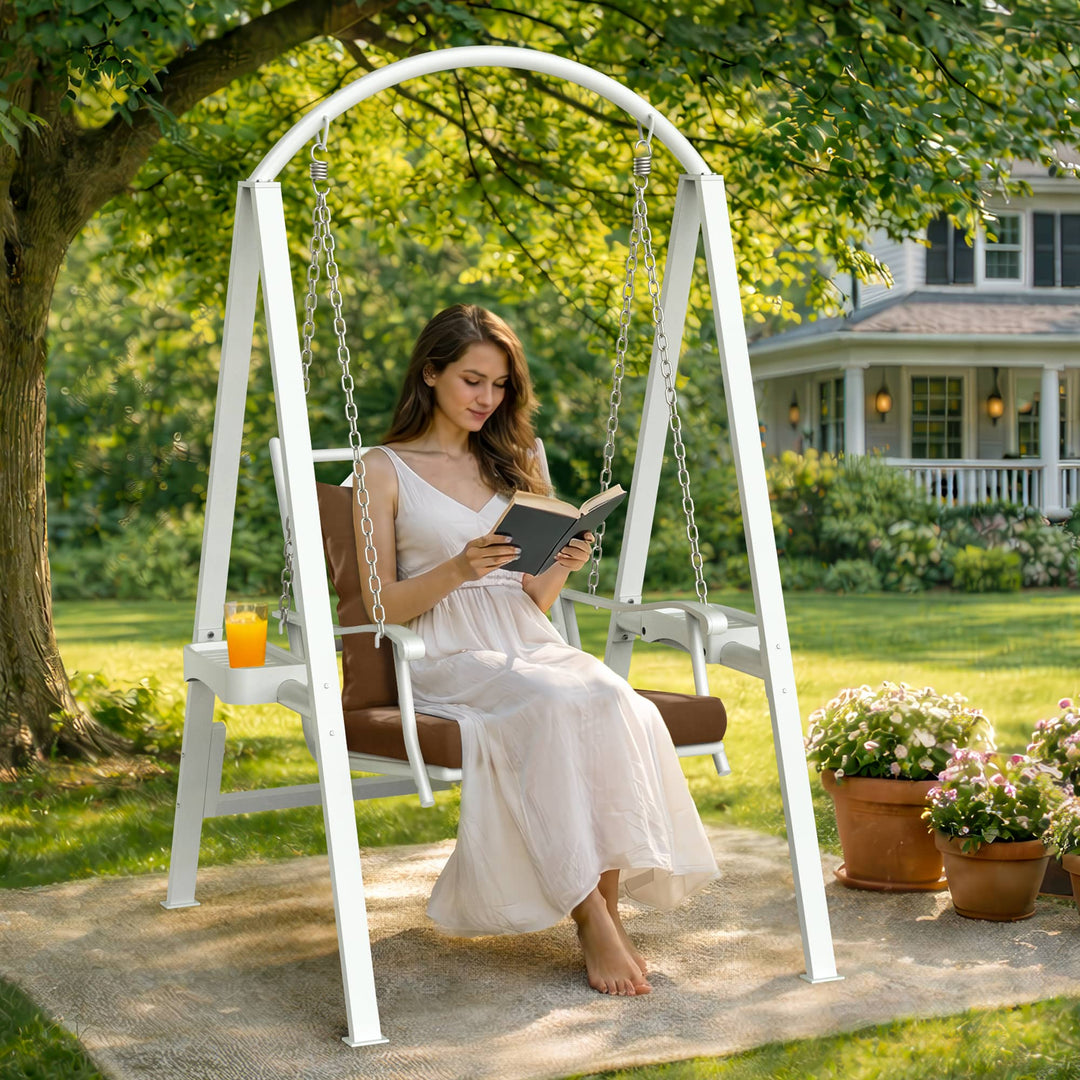 Woman reading on a Pamapic 1-seat porch swing chair in an outdoor garden setting